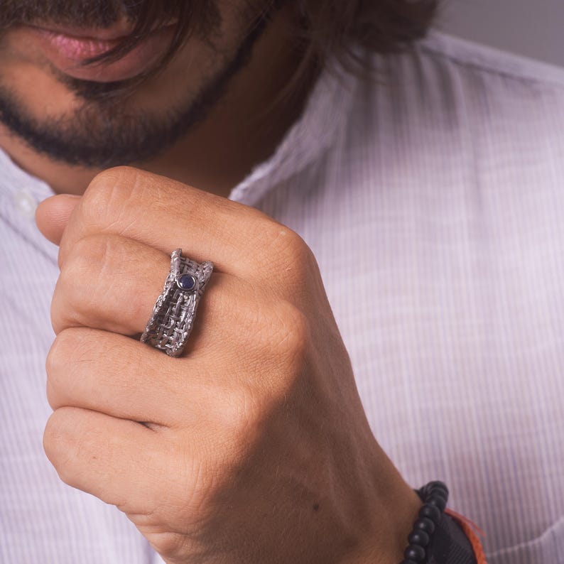 Handmade 925 silver ring with an expressive torn black rhodium-plated design, featuring a deep blue sapphire. A bold, sculptural September birthstone statement ring. Oren Blue Sapphire Ring GERMAN KABIRSKI