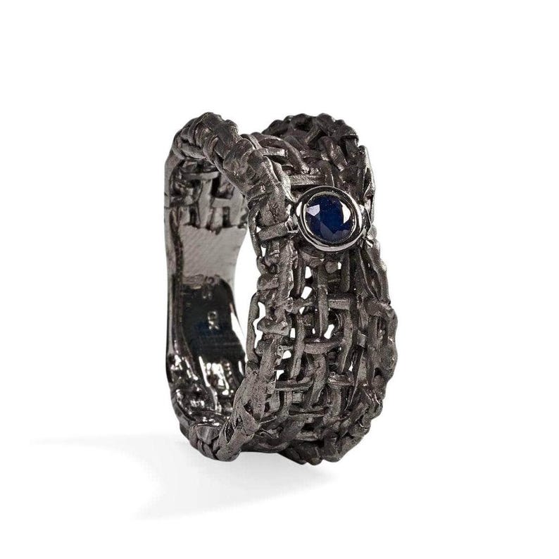 Handmade 925 silver ring with an expressive torn black rhodium-plated design, featuring a deep blue sapphire. A bold, sculptural September birthstone statement ring. Oren Blue Sapphire Ring GERMAN KABIRSKI