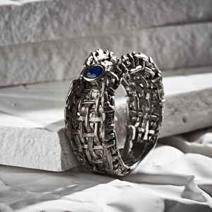Handmade 925 silver ring with an expressive torn black rhodium-plated design, featuring a deep blue sapphire. A bold, sculptural September birthstone statement ring. Oren Blue Sapphire Ring GERMAN KABIRSKI