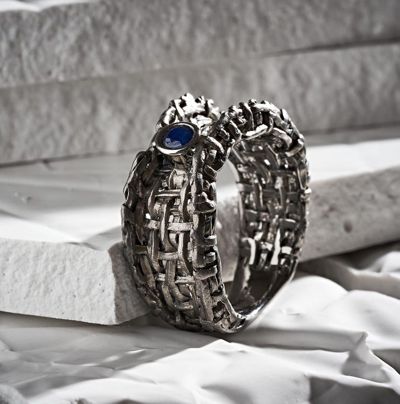 Handmade 925 silver ring with an expressive torn black rhodium-plated design, featuring a deep blue sapphire. A bold, sculptural September birthstone statement ring. Oren Blue Sapphire Ring GERMAN KABIRSKI