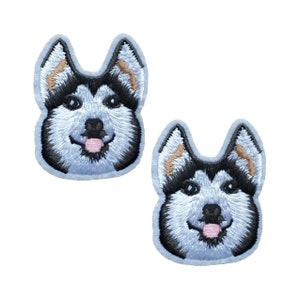 Può includere: Due toppe ricamate da stirare con il viso di un cane husky. Le toppe sono di colore azzurro chiaro con ricami neri e marroni.