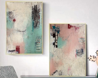 May include: Two abstract paintings with a white background and colourful geometric shapes. The paintings are framed in gold and hung on a white wall.