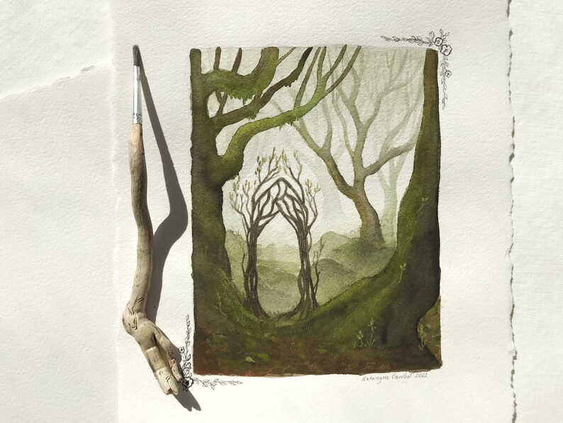 Puede incluir: Pintura a la acuarela de una escena de bosque con un arco central formado por &aacute;rboles. La obra presenta verdes y marrones apagados, con un pincel apoyado en el lado izquierdo. La pintura est&aacute; sobre papel texturizado.