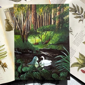 May include: A watercolour painting shows a forest scene with a swan and a figure with long blue hair in the water. The artwork is surrounded by open books with botanical illustrations and text.