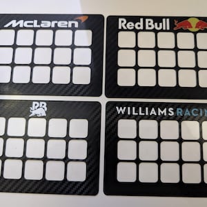 May include: Four black carbon fibre panels with white grid patterns and logos. The logos are McLaren, Red Bull, Williams Racing, and a bull with the letters "DR".