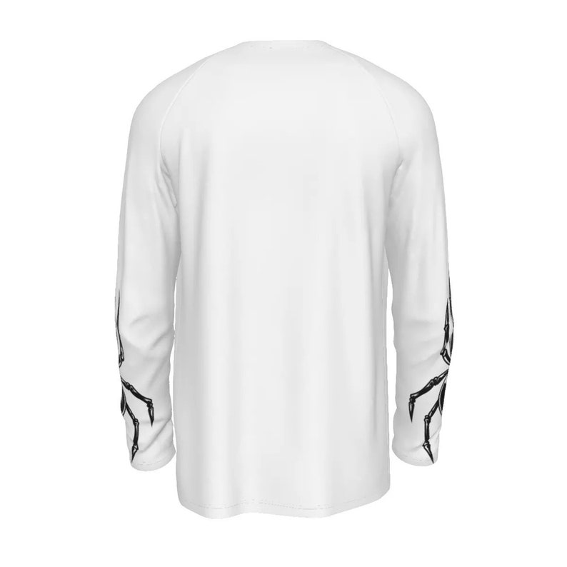 Puede incluir: Camiseta blanca de manga larga con dise&ntilde;os de telara&ntilde;a de ara&ntilde;a negra en las mangas.