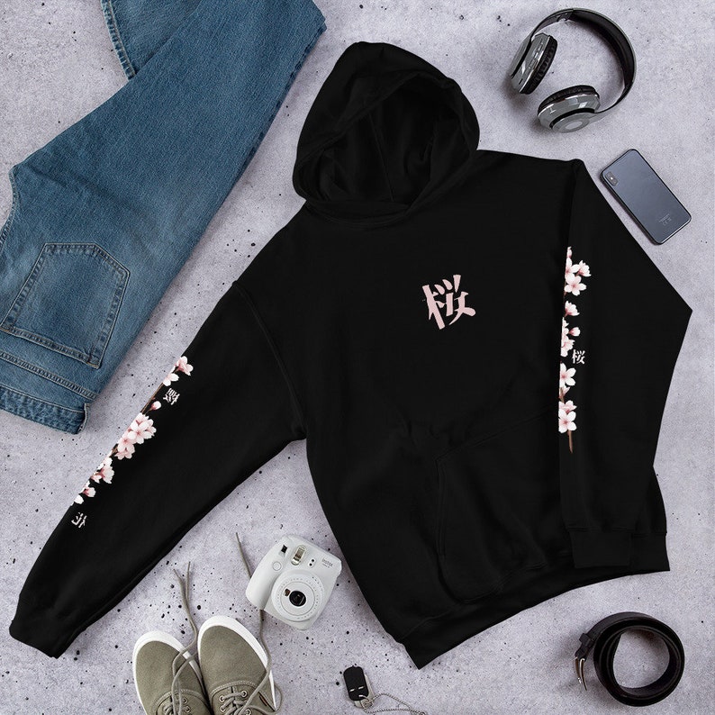 May include: Black hooded sweatshirt with a pink Japanese character on the front and pink cherry blossoms on the sleeves. The character is "桜" which means "cherry blossom".