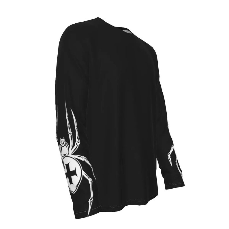 Puede incluir: Camiseta negra de manga larga con un dise&ntilde;o de ara&ntilde;a blanca en las mangas. La ara&ntilde;a tiene una cruz en su abdomen.