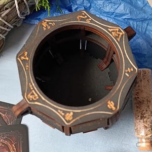 Handcrafted wooden cauldron with aged finish, mystical Wiccan storage box for jewelry, runes, tarot decks, and sacred trinkets, engraved gothic fantasy decor, perfect for pagan rituals and altar setup, dark academia-style wooden storage, rustic handcrafted cauldron chest, magical witchcraft storage, witchy gift idea for Halloween, fantasy altar decor, gothic potion storage, unique arcane symbol box, enchanted wooden Wiccan organizer, witchcraft-themed home decor