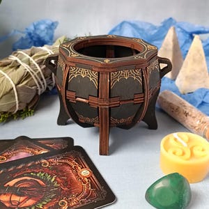 Unique handcrafted witch cauldron box made from wood, engraved with mystical symbols, perfect for storing Wiccan trinkets, spell jars, runes, and magical crystals, enchanted altar decor with gothic aesthetics, rustic aged finish for a fantasy-inspired look, dark academia decor for witches and pagans, perfect Halloween witchcraft accessory, handmade gothic storage for sacred items, fantasy wooden trinket chest, occult-themed altar decoration, handcrafted magical keepsake box