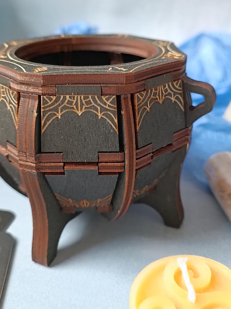 Mystical wooden witch cauldron box with engraved arcane symbols, handcrafted Wiccan trinket holder, gothic altar decor for storing runes, jewelry, and sacred items, enchanted fantasy storage chest, aged wood design with dark academia aesthetic, perfect for Halloween witchcraft decor, handcrafted wooden potion storage, mystical home accent for Wiccans and pagans, rustic fantasy-inspired keepsake box, spell jar organizer, unique handcrafted witchy home decor piece