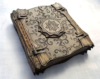 May include: A wooden box with a decorative design and a metal clasp. The box is closed and has a floral design on the front.