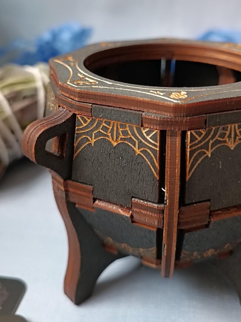 Handmade gothic wooden cauldron storage box, ideal for Wiccan altar decor, witchy jewelry organizer, and spell jar storage, enchanted fantasy trinket holder with mystical engravings, aged distressed wood design, perfect Halloween decor for witches and pagans, dark academia aesthetic altar accessory, handcrafted rustic potion holder, mystical gothic-inspired gift, spiritual home decor piece, unique magic ritual storage, fantasy home accent for gothic and occult lovers