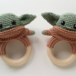 May include: Two crocheted green and brown baby Yoda rattle toys with wooden rings.