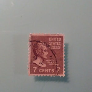 Może przedstawiać: Brązowy znaczek pocztowy Stanów Zjednoczonych z portretem Andrew Jacksona i tekstem "7 CENTS".