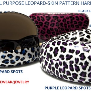 May include: Three hard shell cases with a leopard print design. The cases are in blue, purple, and pink with black spots. The text on the image reads "Designer All Purpose Leopard-Skin Pattern Hard Shell Cases", "Black Leopard Spots on Purple", "Black Leopard Spots", "Blue Leopard Spots", "Sunglasses/Eyewear/Jewelry", and "Purple Leopard Spots".