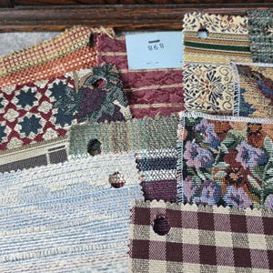 May include: A collection of fabric swatches in various patterns and colors. The swatches include floral, geometric, and striped designs in shades of red, blue, green, and beige. A small tag with the number 868 is visible.