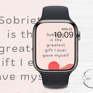 Puede incluir: Un reloj inteligente negro con una esfera blanca que muestra la hora 10:09 y el texto "Sobriety is the greatest gift I ever gave myself". La esfera del reloj también tiene un gráfico de puesta de sol rojo y rosa. El texto "Sober Living Co." es visible en la esquina inferior derecha de la imagen.