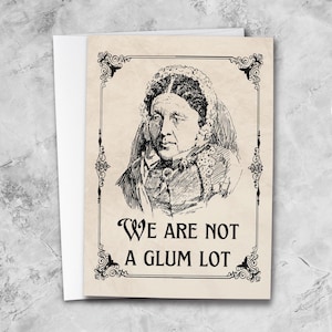 May include: Greeting card featuring a vintage illustration of a woman in a bonnet. The card has a cream-colored background with decorative borders and the text "WE ARE NOT A GLUM LOT" in black.