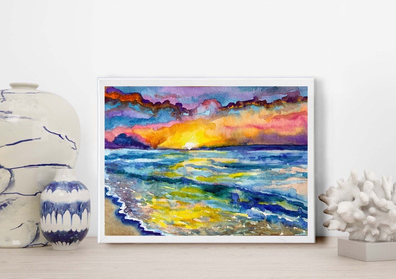 Op de afbeelding: Waterverf schilderij van een zonsondergang boven de oceaan. De lucht is een mix van paars, roze en oranje, met wolken die in het water worden weerspiegeld. De golven zijn een levendig blauw en groen.