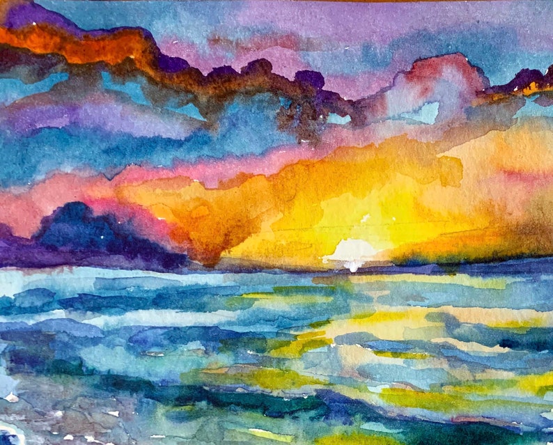 Op de afbeelding: Waterverf schilderij van een zonsondergang boven de oceaan. De lucht is een mix van paars, roze, oranje en geel. Het water is diepblauw met hints van groen en geel.