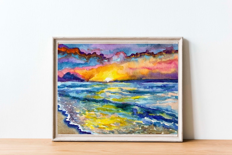 Op de afbeelding: Waterverf schilderij van een zonsondergang boven de oceaan. De lucht is een mix van paars, roze en oranje, met wolken die in het water worden weerspiegeld. De golven zijn blauw en groen, met een zandstrand op de voorgrond.