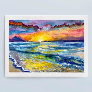 Op de afbeelding: Waterverf schilderij van een zonsondergang boven de oceaan. De lucht is een mix van paars, roze en oranje, met wolken die de kleuren reflecteren. De oceaan is diepblauw, met golven die breken op de kust. Het schilderij is ingelijst in een wit frame.