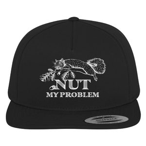May include: Black snapback cap featuring a white illustration of a squirrel on a branch, with the words "NUT MY PROBLEM". The cap has a flat peak and a snap closure. A classic, casual style.
