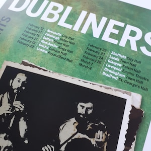 K&ouml;nnte beinhalten: Ein Konzertplakat f&uuml;r The Dubliners mit einem gr&uuml;nen, strukturierten Hintergrund und wei&szlig;em Text, der Tourdaten und Veranstaltungsorte vom 12. Februar bis 4. M&auml;rz auflistet. Unter dem Text befindet sich ein Schwarz-Wei&szlig;-Foto der Bandmitglieder.