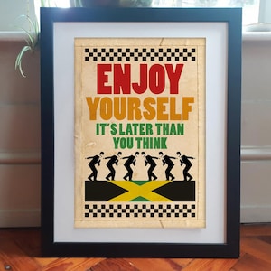 Könnte beinhalten: Ein gerahmtes Poster mit dem Text ENJOY YOURSELF IT'S LATER THAN YOU THINK in Rot, Gelb und Grün. Unter dem Text befinden sich sechs schwarze Silhouetten von Figuren in Anzügen, die über einem gelb-grünen jamaikanischen Flaggendesign gehen.