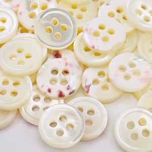 May include: A handmade wooden sign with the text "Welcome" in a handwritten style. The sign is painted white with a distressed finish, and a small green leaf is attached to the top. The sign measures approximately 12 inches wide.