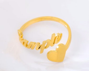 Op de afbeelding: Een gouden ring met het woord "ample" erop gegraveerd. De ring heeft een hartvormig ontwerp aan de zijkant.
