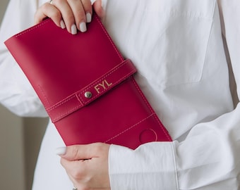 May include: A vibrant magenta leather-like organizer case featuring a horizontal strap with a metallic snap button closure. The strap is embossed with the gold-colored letters FYL. The rectangular case has a smooth finish and a circular cutout detail.