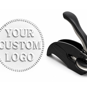 May include: A black handheld embosser tool with a curved lever mechanism, positioned next to a circular white embossed seal featuring the text "YOUR CUSTOM LOGO" in raised lettering with a serrated border design around the outer edge.