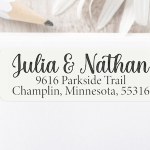 May include: White return address label with black text. The text reads "Julia & Nathan", "9616 Parkside Trail", "Champlin, Minnesota, 55316".