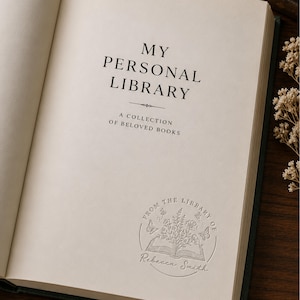 May include: An open book with off-white pages featuring the printed text MY PERSONAL LIBRARY A COLLECTION OF BELOVED BOOKS and a circular embossed stamp at the bottom that reads FROM THE LIBRARY OF Rebecca Smith with floral and butterfly motifs.
