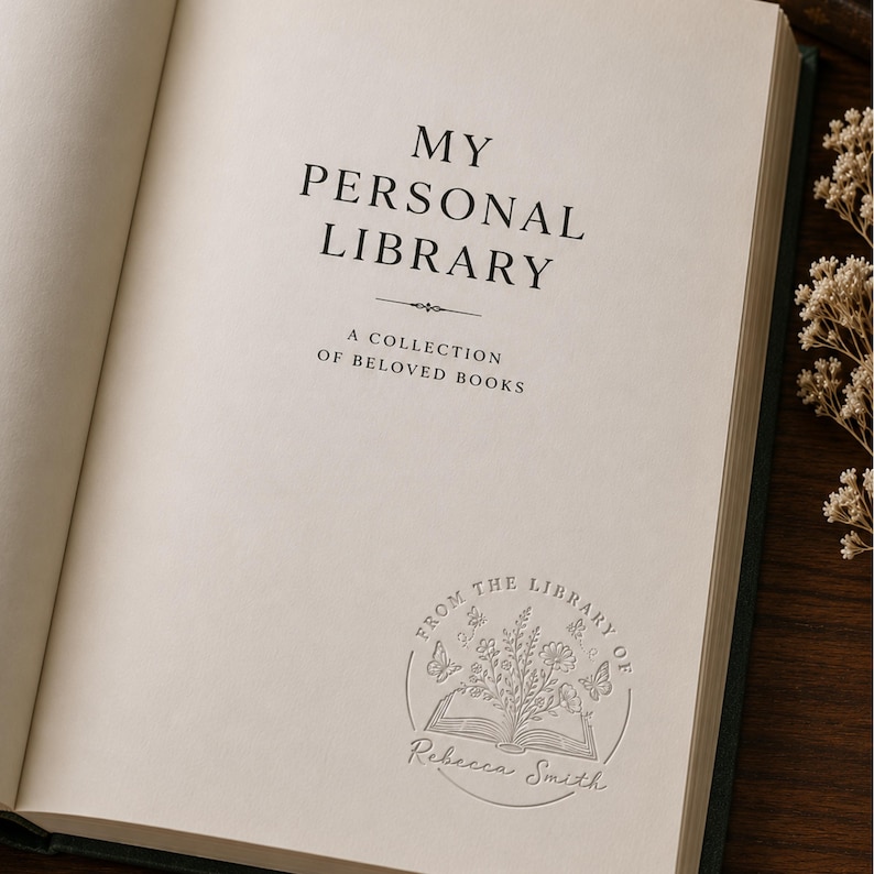 May include: An open book with off-white pages featuring the printed text MY PERSONAL LIBRARY A COLLECTION OF BELOVED BOOKS and a circular embossed stamp at the bottom that reads FROM THE LIBRARY OF Rebecca Smith with floral and butterfly motifs.
