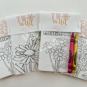 May include: Three white coloring pages with a floral design and the text "TW wild" and "CHARLOTTE" on the top. The pages are packaged in clear plastic bags with two yellow and pink crayons.