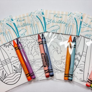 May include: Party favor sets for a 1st birthday celebration. Each set includes a coloring page with a surfboard and ocean scene, crayons, and a decorative label that reads "Thanks for Celebrating Kai's 1st Birthday".