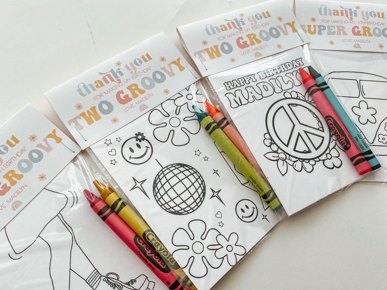 May include: A set of four groovy themed colouring pages with crayons. The colouring pages feature a peace sign, a van, a disco ball, and a girl in a groovy outfit. The text on the pages says "Happy Birthday Madily" and "Thank you for making my birthday two groovy".