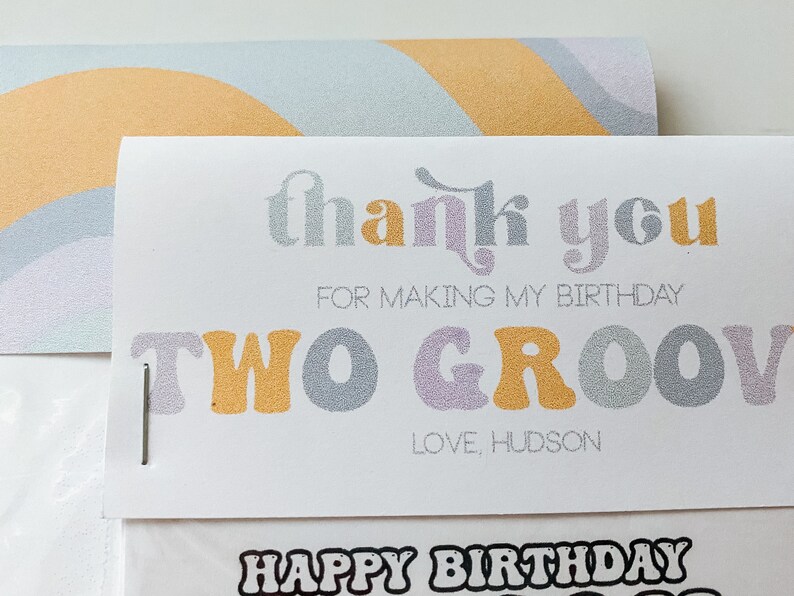 May include: A white thank you card with a rainbow design on the back. The card says "thank you for making my birthday two groovy" and "love, hudson".