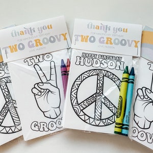 May include: Three colourful thank you cards with the text "Thank you for making my birthday two groovy" and "Love, Hudson". Each card is paired with a colouring page featuring a peace sign, a hand making the peace sign, and the text "Two Groovy". Crayola crayons are included.