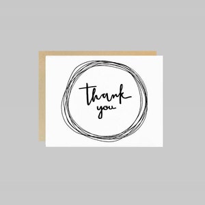 May include: A simple thank you card with the words "thank you" written in black script inside a circle drawn with black lines.
