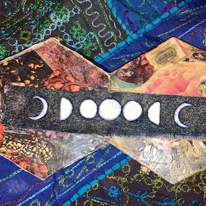 Peut inclure: Une boîte hexagonale avec un collage de papier à motifs colorés et un bandeau en tissu noir avec des phases de lune blanches. La boîte est en carton et a un aspect rustique et vintage.