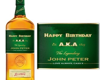 May include: A green and gold personalized bottle label with the text "Happy Birthday Est. A.K.A 1829 The Legendary John Peter Love Always, Cass X"