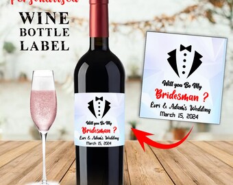 May include: A personalized wine bottle label with a tuxedo graphic and the text "Will you Be My Bridesman? Lori & Adam's Wedding March 15, 2024".
