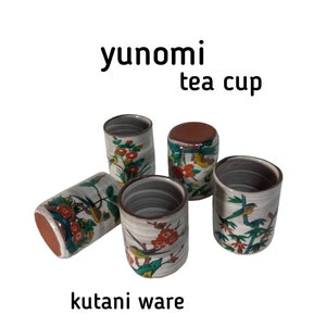 Puede incluir: Conjunto de cinco pequeñas tazas de té de cerámica blanca con diseños florales y de pájaros coloridos. Las tazas se llaman "yunomi" y están hechas de cerámica Kutani.