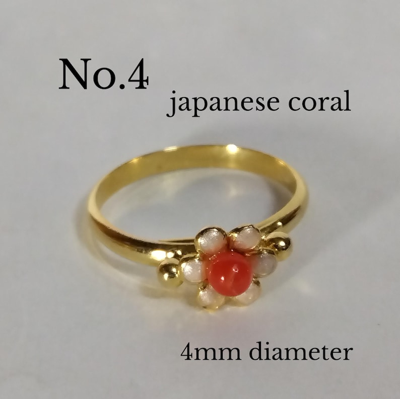 Peut inclure: Bague en or avec un motif de fleur comportant un centre en corail rouge et des accents de perles blanches. La bague est &eacute;tiquet&eacute;e "No. 4 japanese coral" et "4 mm de diam&egrave;tre".