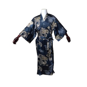 以下が含まれることがあります： ベージュと白のドラゴン柄の濃い青色の着物。着物には広い袖とマッチする帯が付いています。生地は微妙な光沢があり、ドラゴンのデザインは詳細で複雑です。