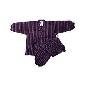 Könnte beinhalten: Ein zweiteiliges japanisches Kimono-Set mit lila und weißen Streifen. Das Oberteil ist eine langärmlige Jacke mit V-Ausschnitt und Bindverschluss. Die passende Hose hat einen elastischen Bund. Der Stoff hat vertikale Streifen.